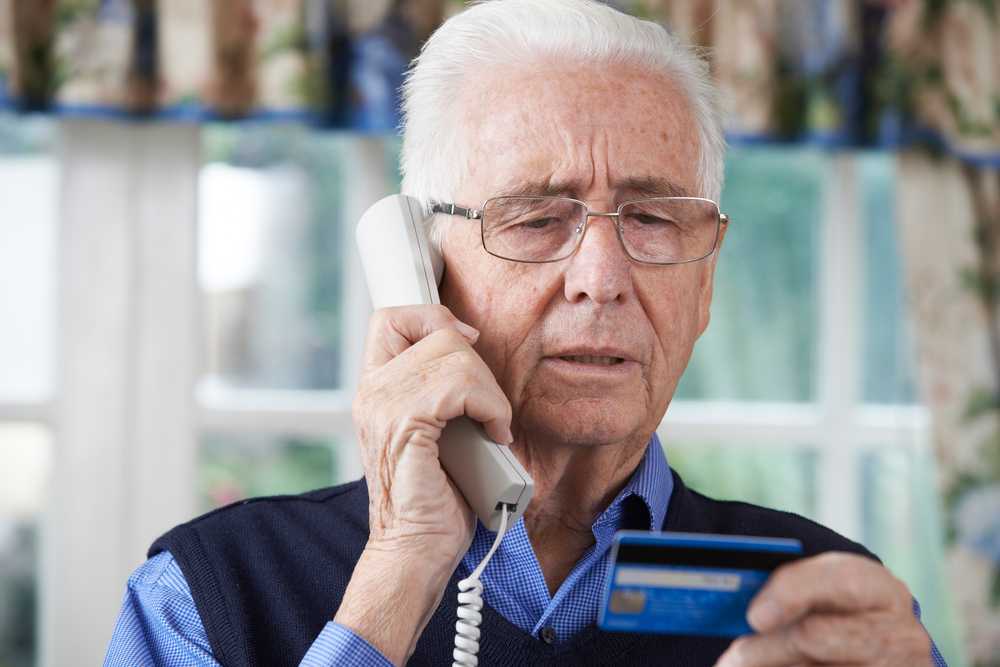 Elderly man giving credit card details over phone