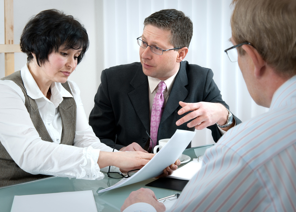 Couple reading through divorce papers with lawyer