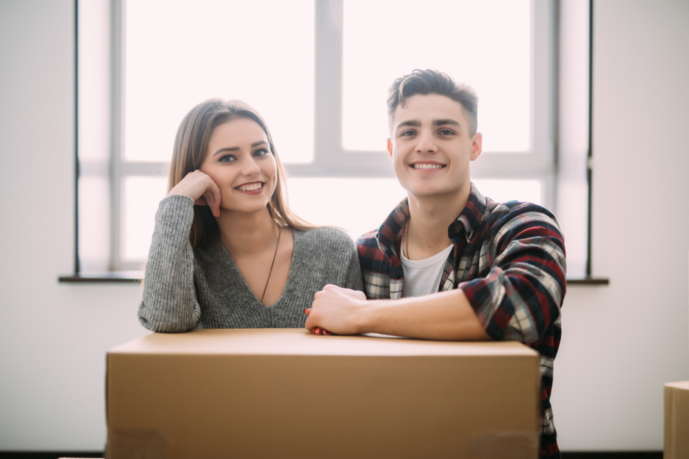 A young couple moving in to their first home with boxes