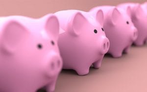 Four pink piggy banks lined up next to one another.