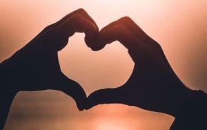 Two hands held together forming the shape of a love heart.
