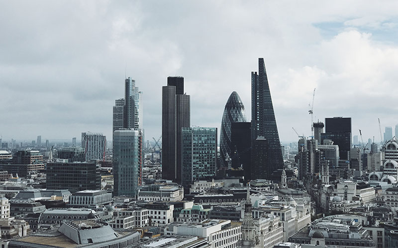 A skyline view of London, with a cloudy sky behind.