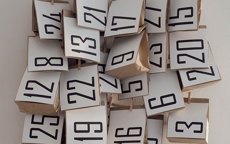 Lots of brown paper bags, each with a number attached to the front.