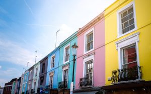 A row of bright multi-coloured houses with a blue sky behind them.
