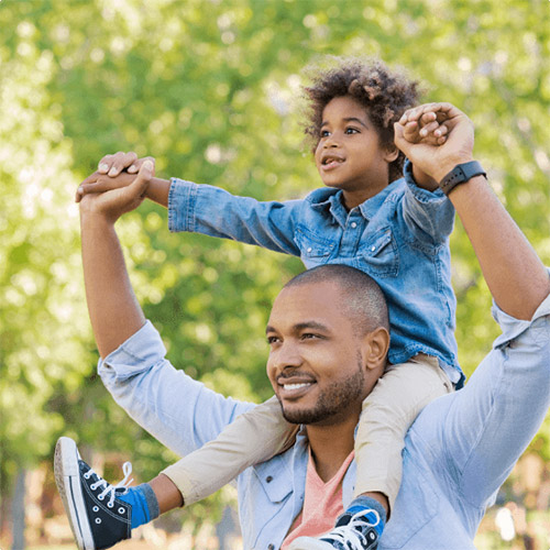 inspiring-better-futures-500x500 A father with his son on his shoulders, on a sunny day in the park