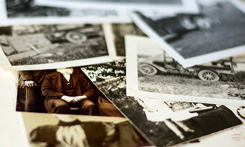 A table covered with historical black & white photographs