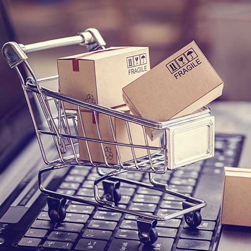 A miniature shopping trolley full of boxes, sat on top of a laptop - are you in control of your spending