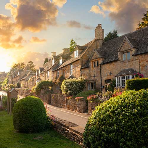 A sunset scene of a row of old houses in the Cotswolds