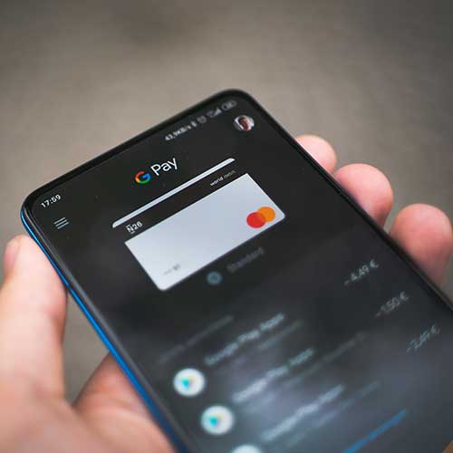 cashless-society-500x500 A hand holding a mobile phone