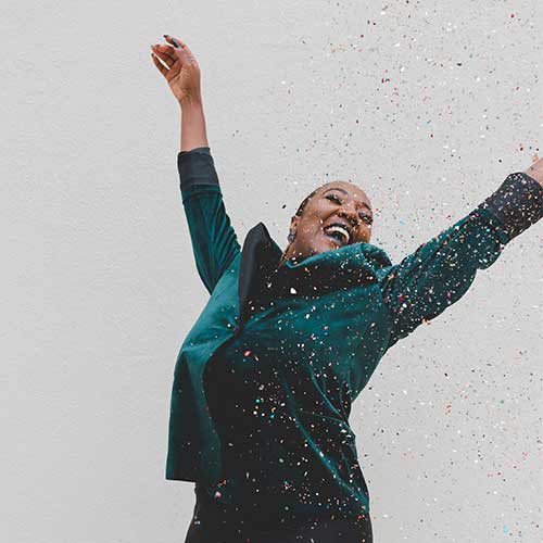 A woman celebrating among confetti