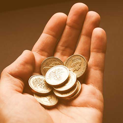 A hand holding a number of coins