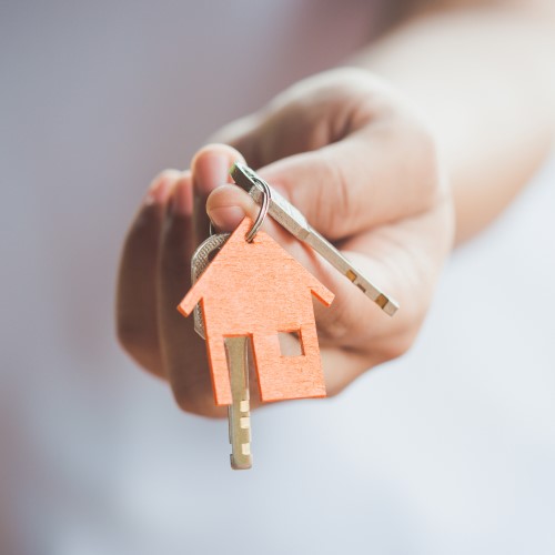 Stock_keys_house_500x500 A hand holding a set of keys with a house-shaped keyring
