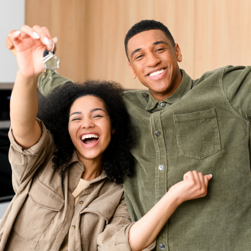 Couple in a kitchen dangling their new keys