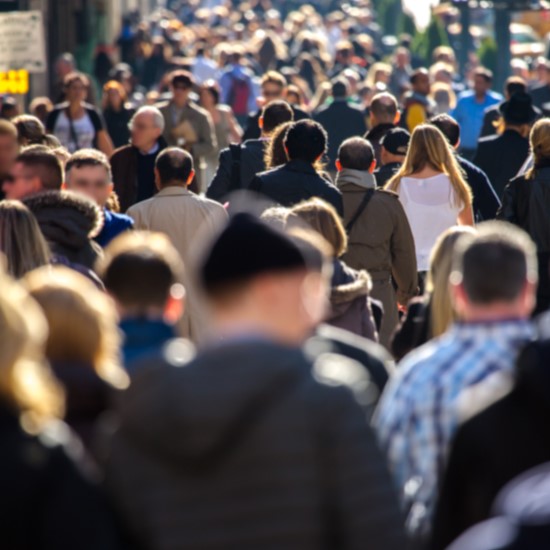 Crowd of people walking down a street