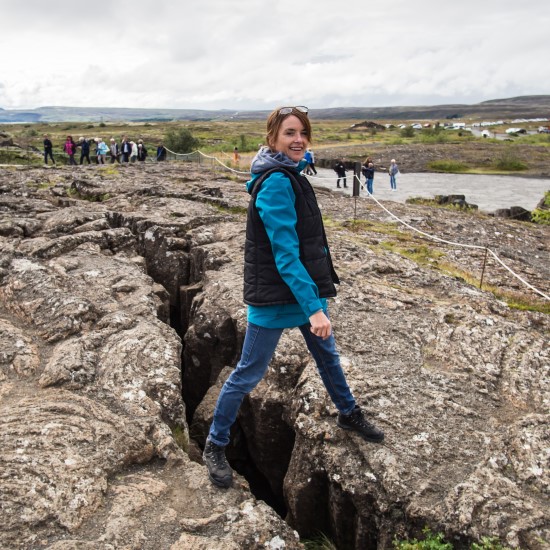 Woman stood on an earth gap at Thingvellir National Park in Iceland