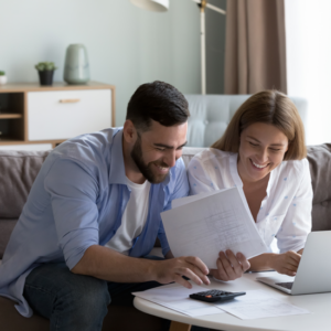 Happy couple working together using a laptop and calculator