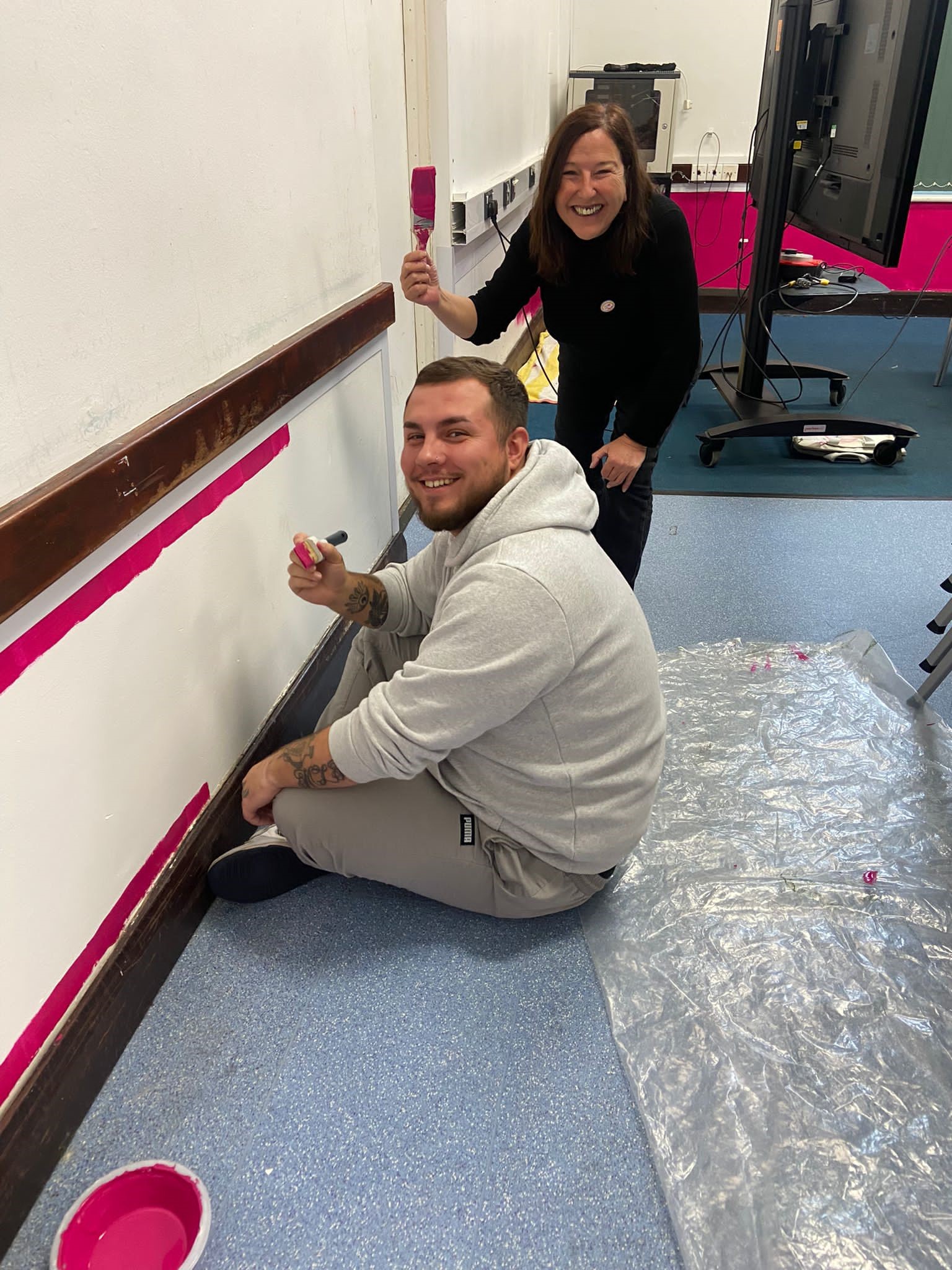 Two OneFamily colleagues painting