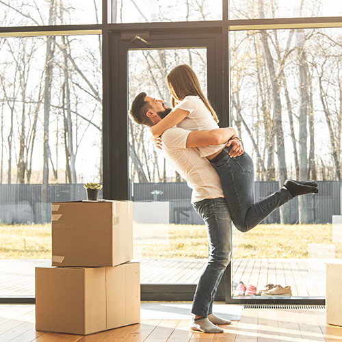 young couple moves to a new home. the family carries boxes of things after buying a home.