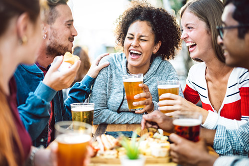food-drink-member-benefits-onefamily Group of friends laughing around a table