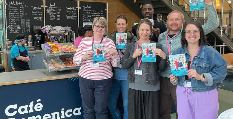 OneFamily staff members in a Cafe Domenica giving out leaflets for Team Domenica