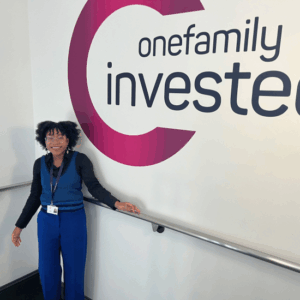 Sophia St Cyr standing next to a sign that says OneFamily invested