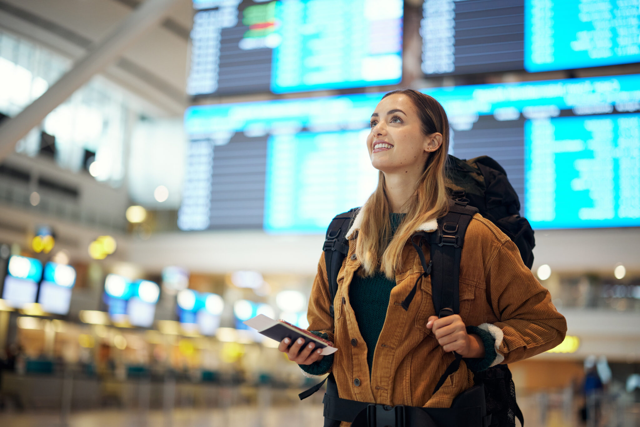 Woman wearing backpack holding phone