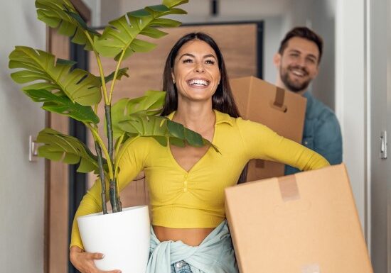 Man and woman carrying moving boxes