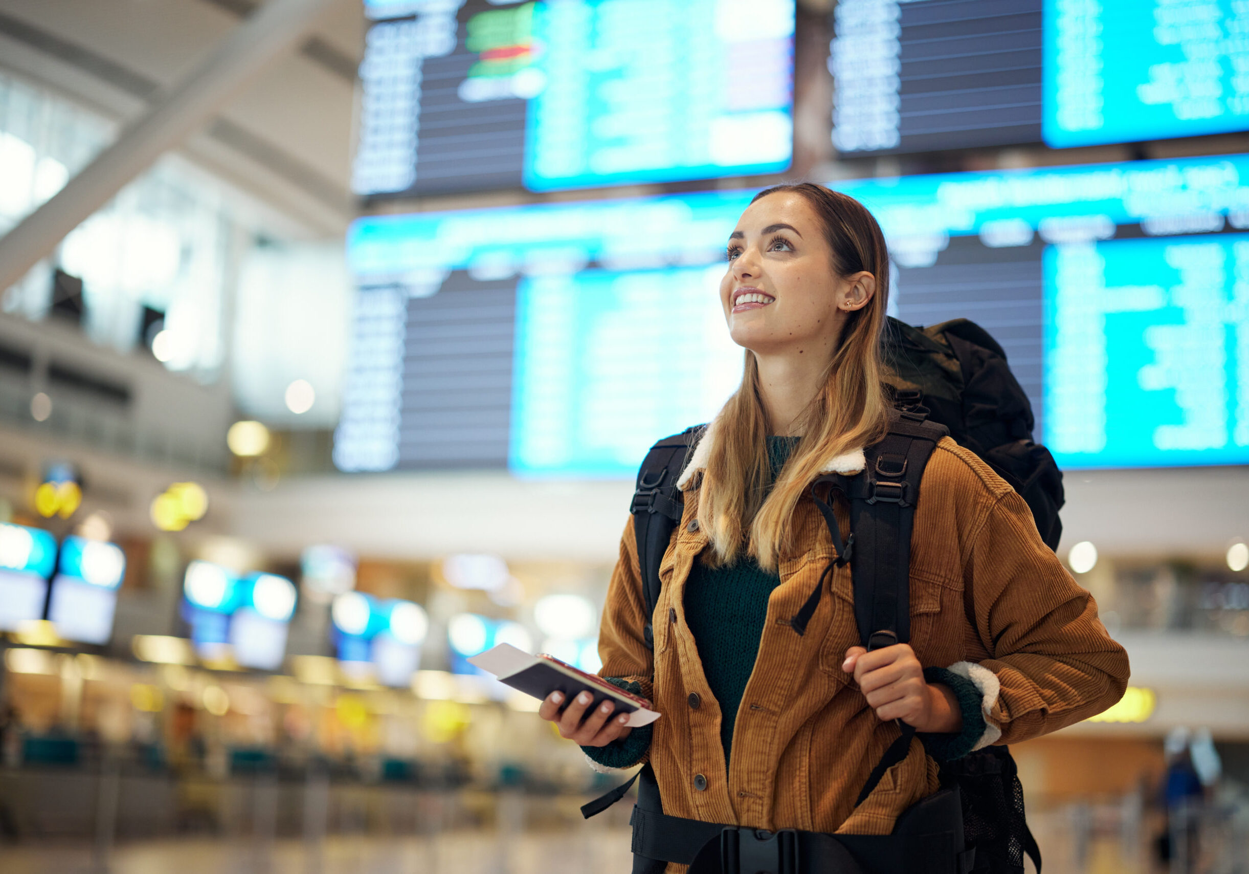 Woman wearing backpack holding phone