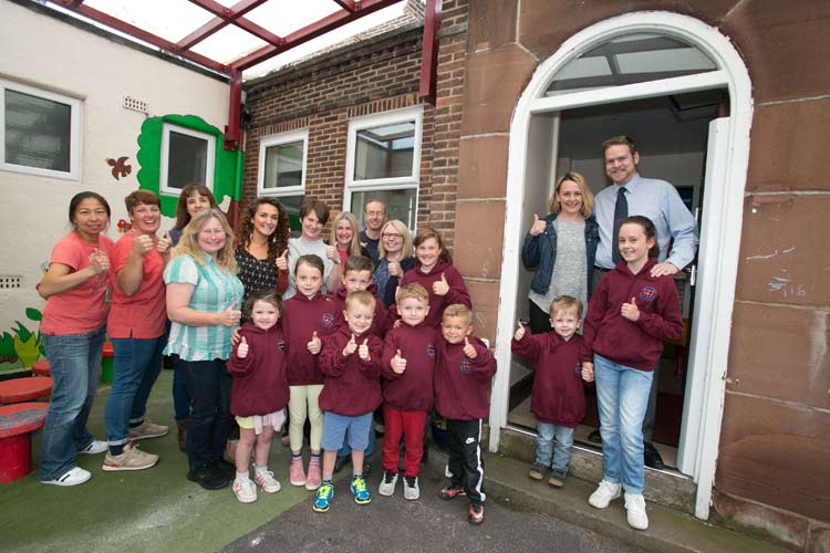 Teachers and children of St Mary Magdalen's stand in the school doorway