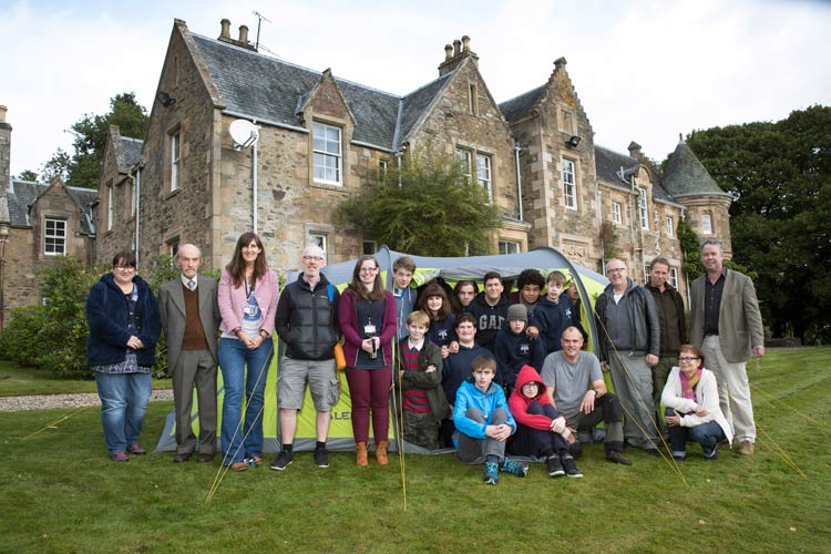 Teachers and pupils stand in front of an old school building