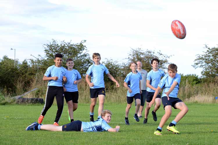 Teenage boys playing rugby