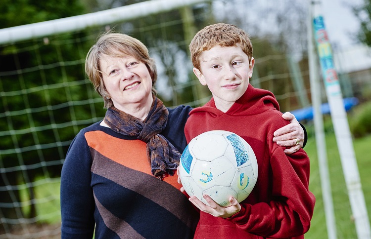maxine-kinchin A woman stands in front of a goal with a young boy, who is holding a football