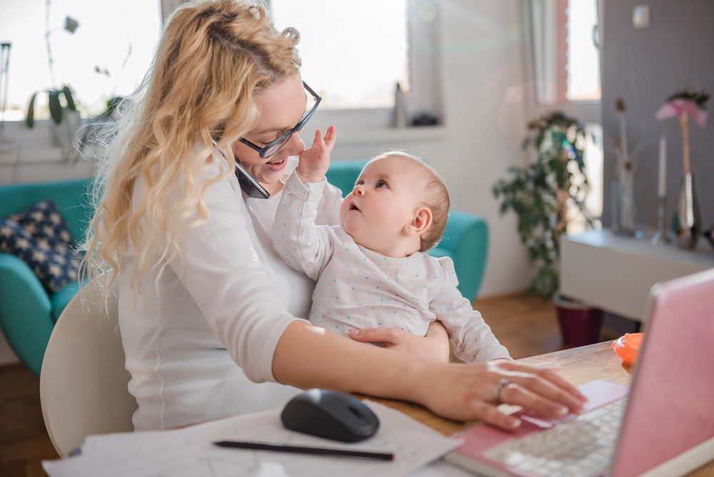Mother with baby working at her desk