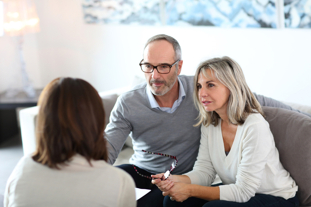Over 50s couple sitting with financial adviser