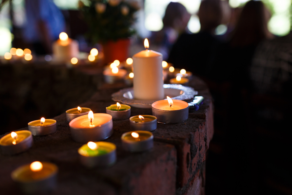 Funeral candles with people in the background