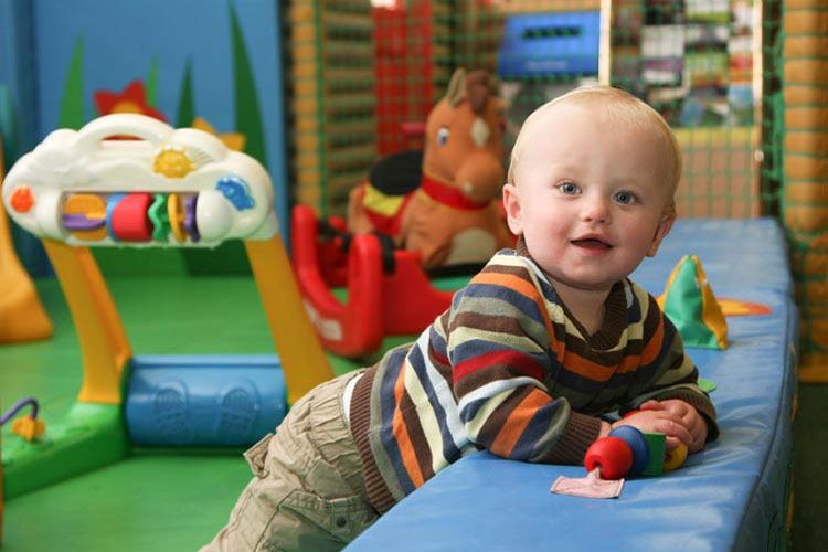 A toddler plays in a soft play area.