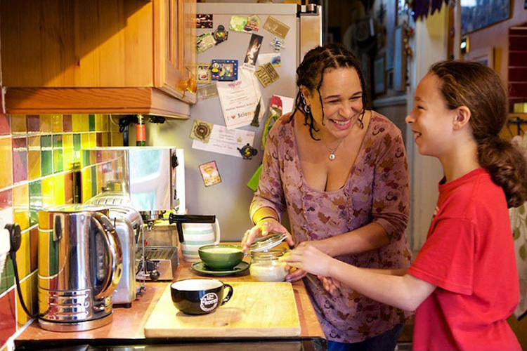 A woman and her daughter at work in the kitchen.