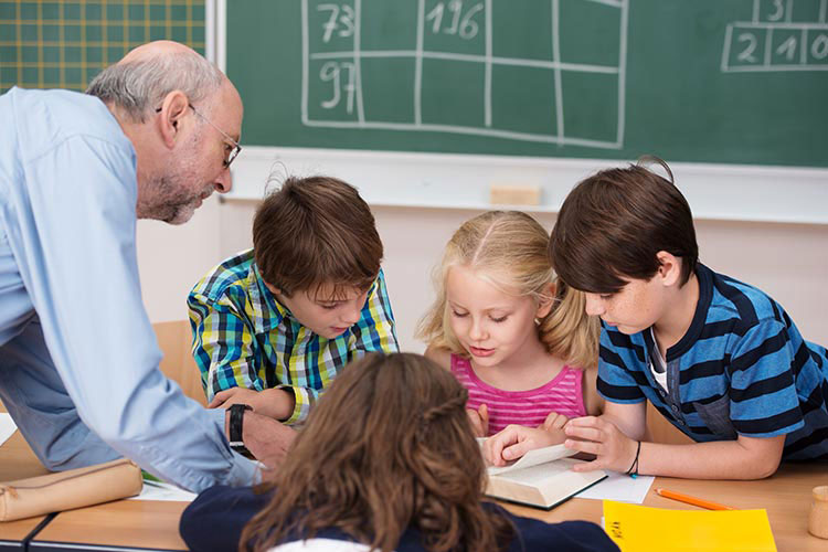 A teacher works with a group of children in the classroom.
